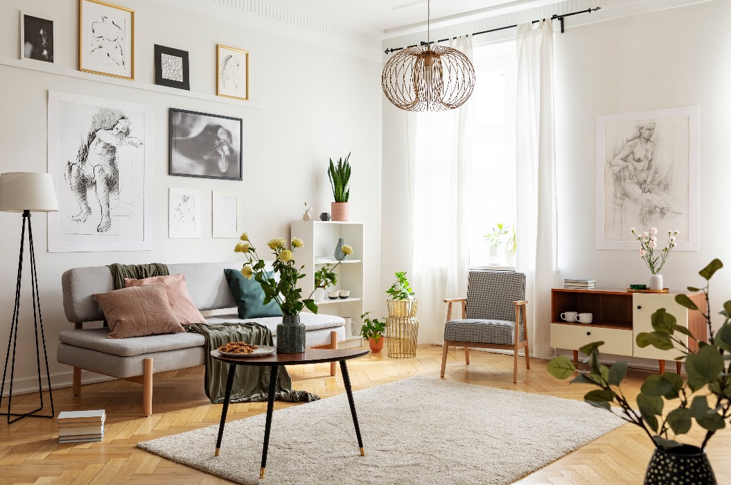 Tisch mit Blumen auf Teppich in Wohnung Interieur mit Plakaten